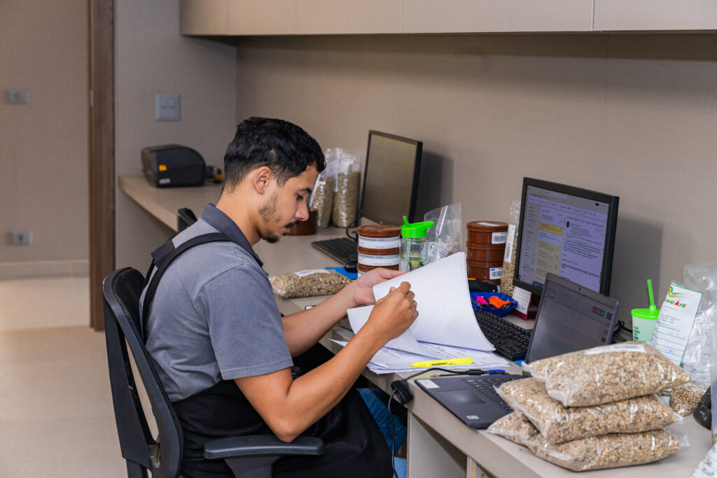 Quality control at the cooperative, where a young Q-grader is analyzing the specialty coffee roast on a computer.