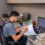 Quality control at the cooperative, where a young Q-grader is analyzing the specialty coffee roast on a computer.